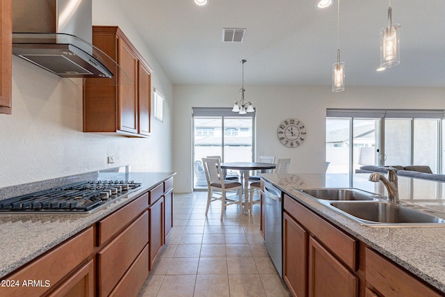 kitchen with sink, stainless steel appliances, wall chimney range hood, a notable chandelier, and pendant lighting