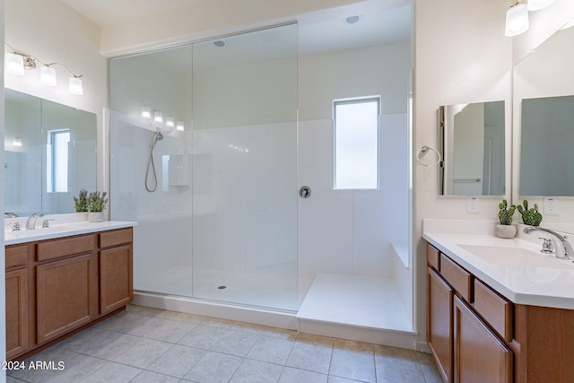 bathroom featuring tile patterned flooring, vanity, and a shower