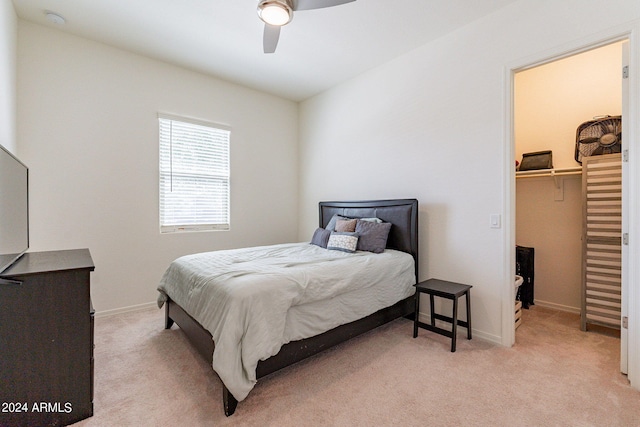 carpeted bedroom featuring a spacious closet, a closet, and ceiling fan