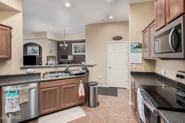14575 W Mountain View Blvd Unit 12309, Surprise, AZ 85374 - kitchen featuring appliances with stainless steel finishes, dark countertops, brown cabinets, and recessed lighting