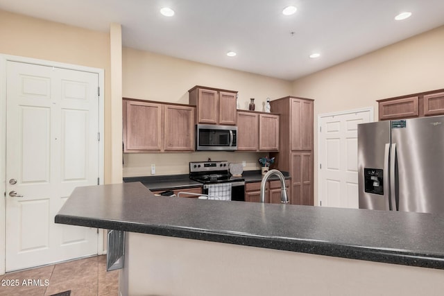 14575 W Mountain View Blvd Unit 12309, Surprise, AZ 85374 - kitchen with stainless steel appliances, dark countertops, light tile patterned floors, and recessed lighting