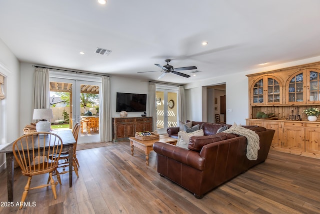 living area featuring dark wood-type flooring, a ceiling fan, visible vents, and recessed lighting