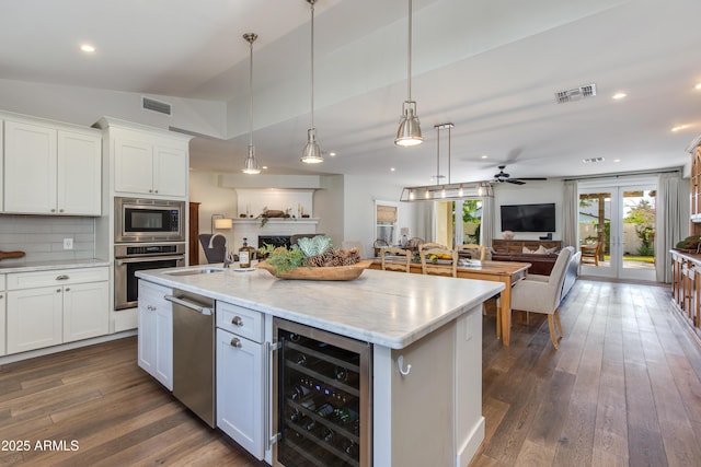 kitchen with stainless steel appliances, wine cooler, a sink, and visible vents