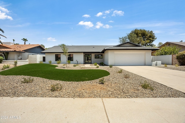 ranch-style home with an attached garage, fence, driveway, stucco siding, and a front yard