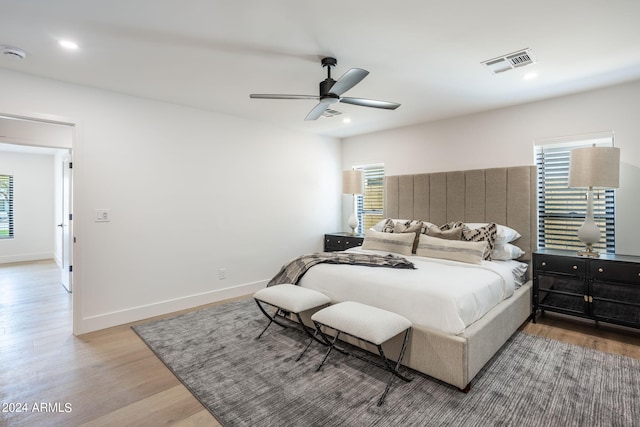 bedroom with baseboards, visible vents, wood finished floors, and recessed lighting