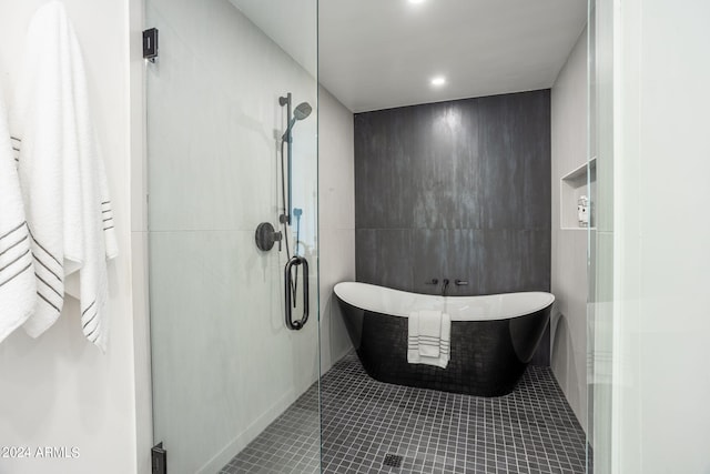 bathroom with tile patterned flooring, recessed lighting, tile walls, a freestanding bath, and a stall shower