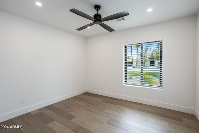 spare room with recessed lighting, wood finished floors, a ceiling fan, visible vents, and baseboards