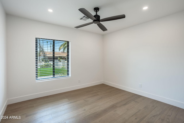 unfurnished room with recessed lighting, wood finished floors, visible vents, and baseboards