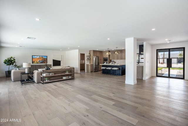 living room with light wood-style floors, visible vents, and recessed lighting