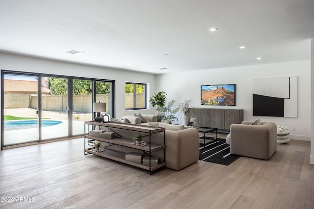 living area with light wood finished floors, baseboards, visible vents, and recessed lighting