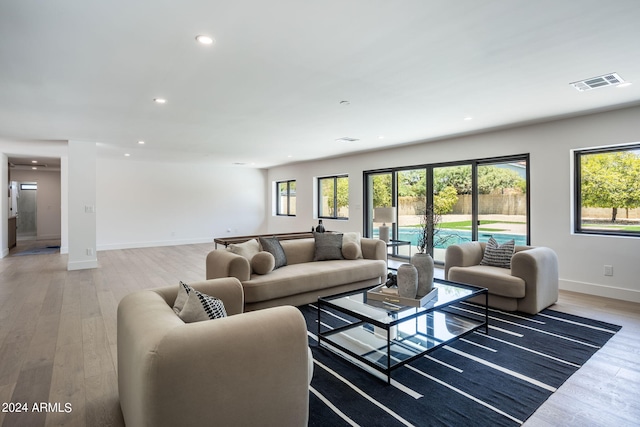 living area with light wood-type flooring, baseboards, visible vents, and recessed lighting