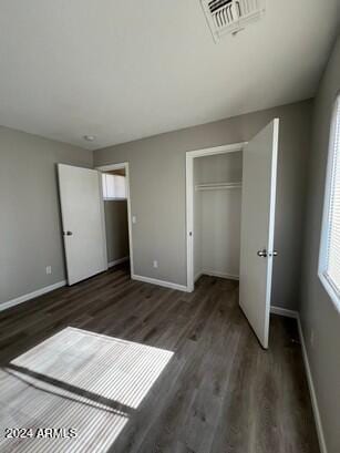 unfurnished bedroom featuring dark hardwood / wood-style flooring and a closet