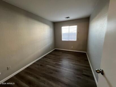 spare room featuring dark wood-type flooring