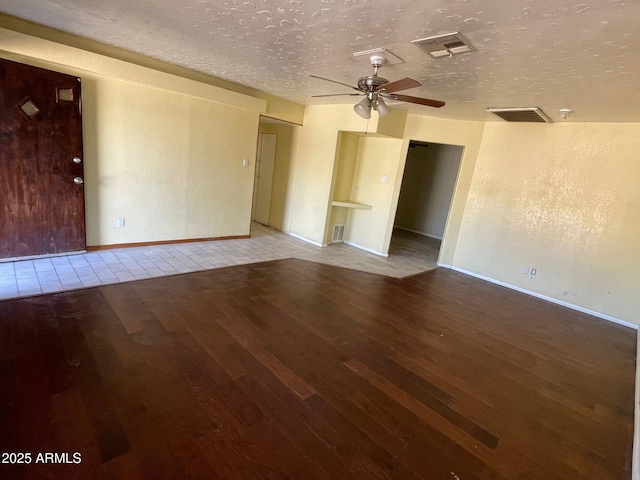 empty room with a textured ceiling, ceiling fan, and hardwood / wood-style flooring