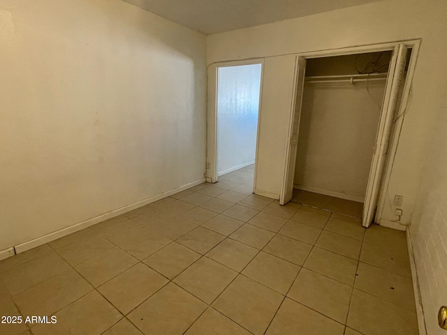 unfurnished bedroom featuring a closet and light tile patterned flooring