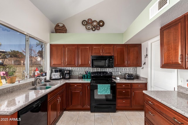 kitchen with lofted ceiling, sink, light stone counters, black appliances, and backsplash