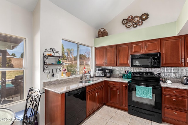 kitchen featuring light stone countertops, sink, backsplash, and black appliances