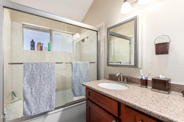 bathroom with vanity, bath / shower combo with glass door, and lofted ceiling