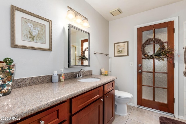 bathroom featuring vanity, tile patterned floors, and toilet