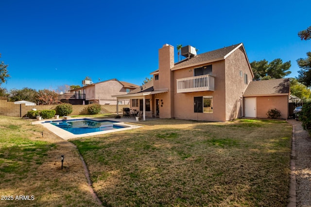 back of property featuring a fenced in pool, a balcony, a yard, and a patio area