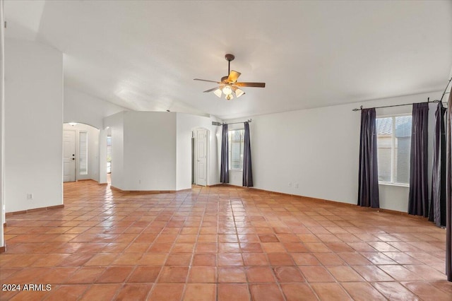 spare room featuring vaulted ceiling, ceiling fan, and light tile patterned flooring