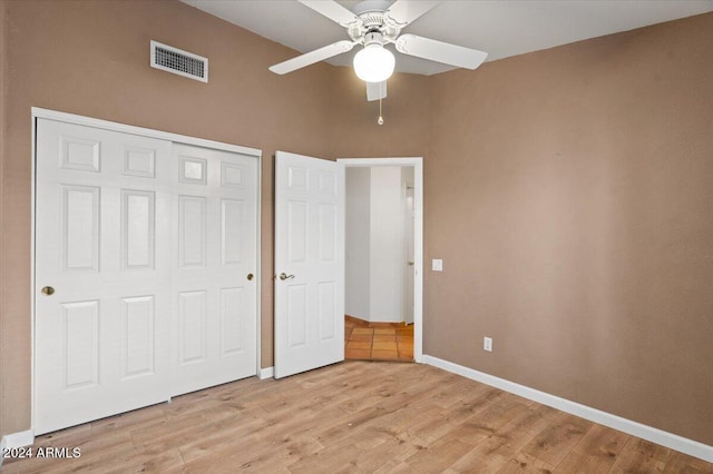 unfurnished bedroom with a closet, light hardwood / wood-style flooring, and ceiling fan