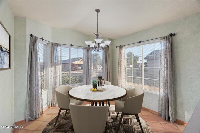 tiled dining space with vaulted ceiling and a notable chandelier