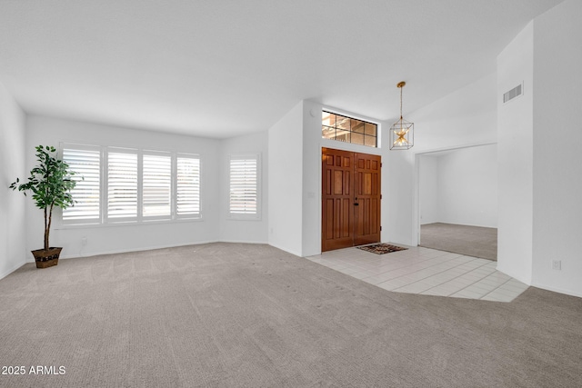 carpeted foyer with vaulted ceiling