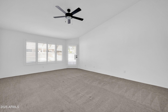 spare room with ceiling fan, lofted ceiling, and light carpet