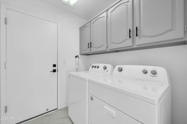 washroom featuring cabinets and washer and clothes dryer