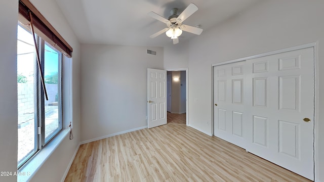 unfurnished bedroom featuring ceiling fan, light hardwood / wood-style floors, and a closet