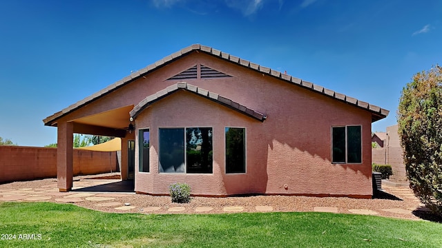 back of house featuring a yard and ceiling fan