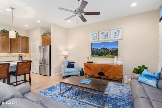 living room featuring light hardwood / wood-style floors and ceiling fan