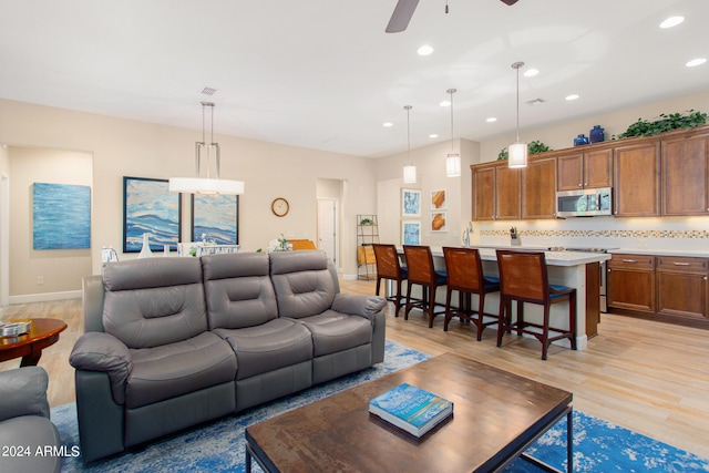 living room featuring ceiling fan and light wood-type flooring