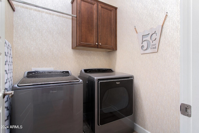 washroom featuring washer and clothes dryer and cabinets