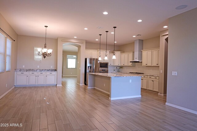 2811 S Jeffry St, Gilbert, AZ 85295 - kitchen featuring wall chimney range hood, arched walkways, light wood finished floors, a chandelier, and recessed lighting