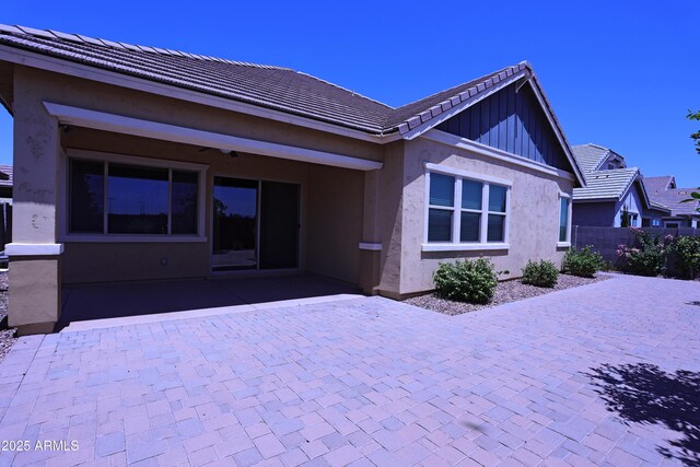 2811 S Jeffry St, Gilbert, AZ 85295 - rear view of property featuring a patio, a tiled roof, stucco siding, and board and batten siding