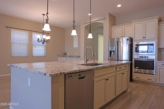 2811 S Jeffry St, Gilbert, AZ 85295 - kitchen featuring stainless steel appliances, light wood finished floors, arched walkways, light stone countertops, and recessed lighting