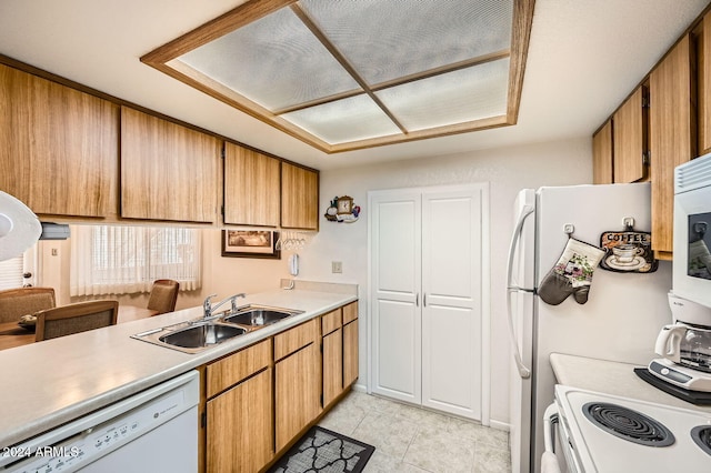 kitchen with white appliances, sink, and light tile patterned floors