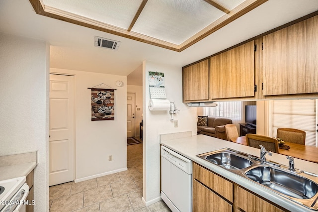 kitchen with dishwasher, stove, light tile patterned floors, and sink