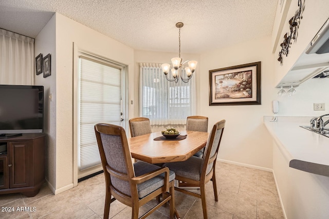 dining area with a notable chandelier, light tile patterned floors, and a textured ceiling