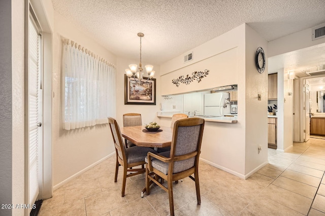 dining room with a textured ceiling, an inviting chandelier, and light tile patterned flooring