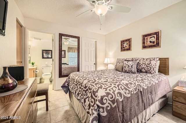 tiled bedroom featuring ceiling fan, a textured ceiling, and ensuite bath