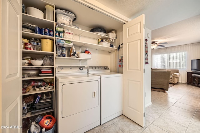 washroom featuring a textured ceiling, washing machine and dryer, light tile patterned floors, and ceiling fan