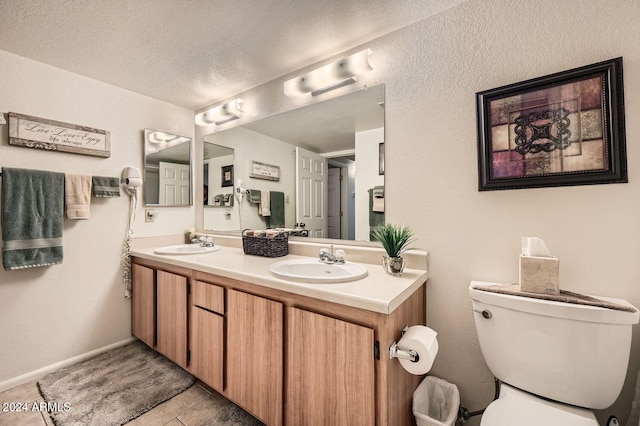 bathroom with a textured ceiling, vanity, and toilet