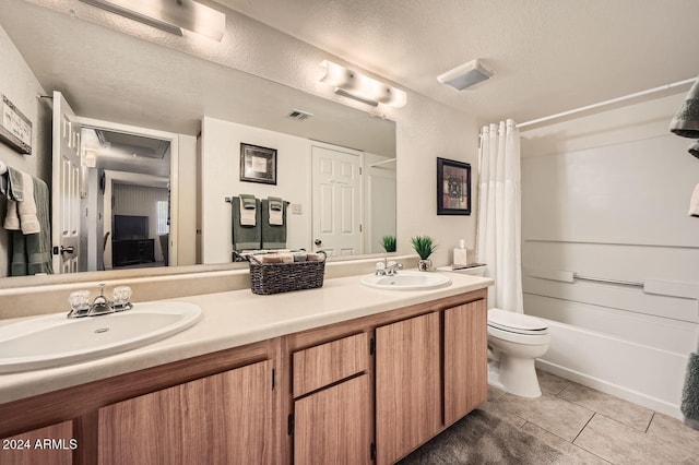 full bathroom with shower / bath combination with curtain, tile patterned floors, vanity, a textured ceiling, and toilet