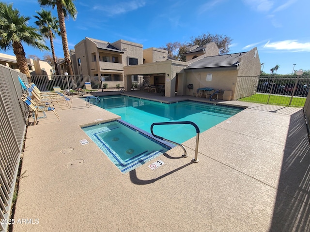 view of swimming pool with a patio area and a hot tub