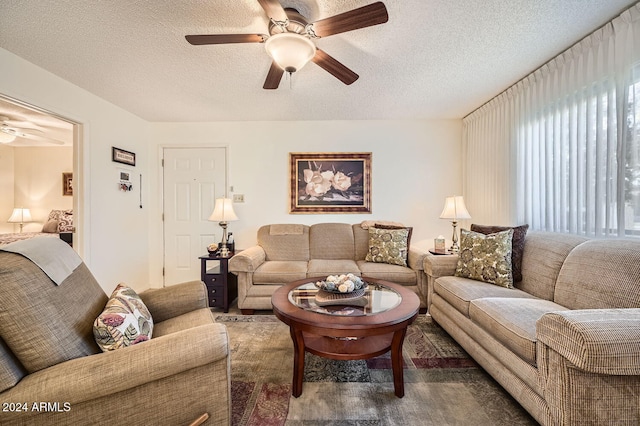 living room featuring ceiling fan and a textured ceiling