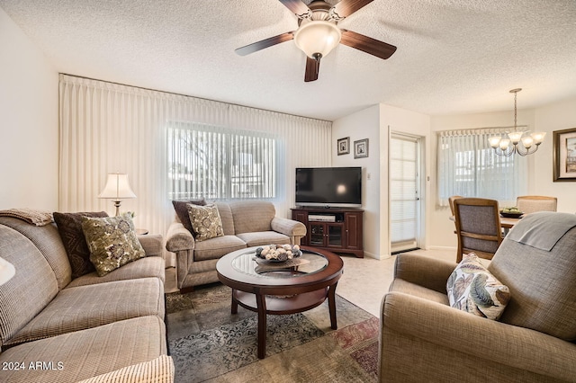 carpeted living room featuring ceiling fan with notable chandelier and a textured ceiling