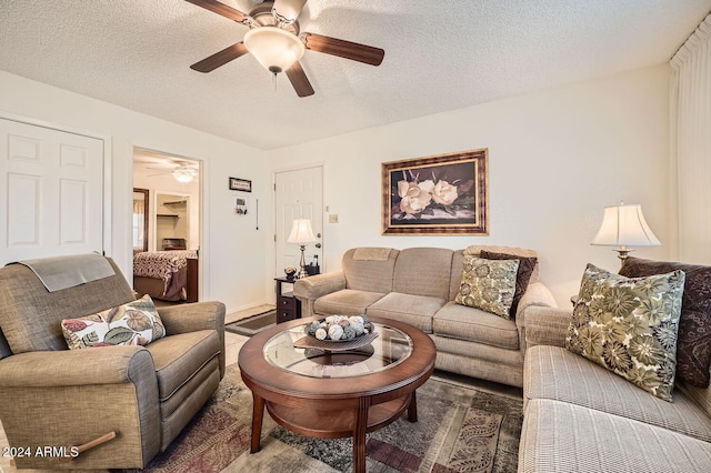 living room featuring ceiling fan and a textured ceiling